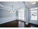 Dining room with dark wood floors, modern light fixture, and bright white trim at 5712 Kendrick Ln, Cumming, GA 30041