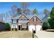 Charming two-story brick home with a well-manicured lawn and a two-car garage at 5712 Kendrick Ln, Cumming, GA 30041