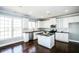 Modern kitchen with white cabinets, stainless steel appliances, island, and granite countertops at 5712 Kendrick Ln, Cumming, GA 30041
