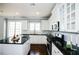 Bright kitchen with stainless steel appliances, a kitchen island, and dark countertops at 5712 Kendrick Ln, Cumming, GA 30041