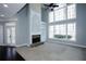 Bright living room with fireplace, large windows, and neutral carpet at 5712 Kendrick Ln, Cumming, GA 30041