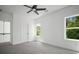 This bedroom features carpeted floors, two windows offering natural light, and a modern ceiling fan at 6470 Pond View Dr, Cumming, GA 30028