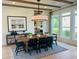 Bright dining room with stylish chandelier, farmhouse table, beams, and natural light from large windows at 6470 Pond View Dr, Cumming, GA 30028