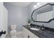 Bathroom showcasing granite countertop, white cabinets, modern fixtures, toilet, and a decorative mirror at 9985 High Falls Pointe, Johns Creek, GA 30022