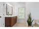 Well-lit bathroom features a wood vanity with a white countertop, complementing the bright interior and window view at 9985 High Falls Pointe, Johns Creek, GA 30022