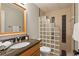 Bathroom featuring a brown marble sink top, glass block shower, and a large wood framed mirror at 9985 High Falls Pointe, Johns Creek, GA 30022
