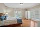 Bright bedroom with hardwood floors, double doors to the outside, and a queen sized bed at 9985 High Falls Pointe, Johns Creek, GA 30022