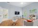 Spacious bedroom with light blue walls, hardwood floors, entertainment center, and a large window at 9985 High Falls Pointe, Johns Creek, GA 30022