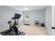 Carpeted home gym featuring exercise bike, weights, window with natural light, and neutral paint at 9985 High Falls Pointe, Johns Creek, GA 30022