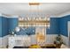 Dining area featuring blue wallpaper, an ornate lighting fixture, and a glimpse into an adjacent room at 9985 High Falls Pointe, Johns Creek, GA 30022