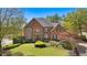 Beautiful two-story brick home with a manicured front lawn and mature trees in a desirable neighborhood at 9985 High Falls Pointe, Johns Creek, GA 30022