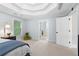 Bright main bedroom boasts tray ceilings, neutral paint, and seamless transition to an ensuite bathroom at 9985 High Falls Pointe, Johns Creek, GA 30022