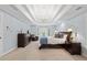 Serene main bedroom with tray ceilings, a chandelier, a bay window and elegant decor at 9985 High Falls Pointe, Johns Creek, GA 30022