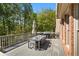 Outdoor deck featuring a dining table, chairs and grill with views of the surrounding trees and scenery at 9985 High Falls Pointe, Johns Creek, GA 30022