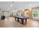 Large recreation room with a pool table, tile flooring, a stone wall with an alcove, and natural light at 9985 High Falls Pointe, Johns Creek, GA 30022