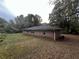 Exterior side view of a brick house with lush green space and trees in the background at 2369 Christian Cir, Covington, GA 30016