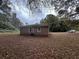 Brick house exterior with leafy yard and a view of the back of the home with a car parked nearby at 2369 Christian Cir, Covington, GA 30016