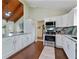 Well-lit kitchen boasts stainless steel appliances, granite countertops, wooden floors, and white cabinets at 3696 Suwanee Creek Ct, Suwanee, GA 30024