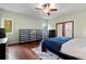 Spacious bedroom features wooden floors, a ceiling fan, and doors to a balcony at 3696 Suwanee Creek Ct, Suwanee, GA 30024