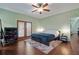 Bright bedroom boasts wooden floors, a ceiling fan, and doors to a balcony at 3696 Suwanee Creek Ct, Suwanee, GA 30024
