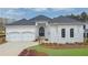 Beautiful white brick home with a manicured lawn, arched windows, a two-car garage and a dark, arched front door at 103 Candler Loop, Acworth, GA 30101