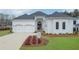 Beautiful white brick home with a manicured lawn, arched windows, a two-car garage and a dark, arched front door at 103 Candler Loop, Acworth, GA 30101