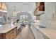 Island kitchen with a farmhouse sink and stainless appliances that opens to a sun-lit dining area at 103 Candler Loop, Acworth, GA 30101
