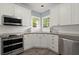 Well-lit kitchen with stainless steel appliances, white cabinets, tile backsplash, and a double oven at 1363 Brentwood Ln, Marietta, GA 30062