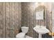 Charming powder room with a pedestal sink, decorative wallpaper, and gold fixtures at 1363 Brentwood Ln, Marietta, GA 30062