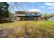 Wide backyard with green grass shows home exterior with deck, patio and screened in porch at 1612 Sky Crest Dr, Lithia Springs, GA 30122