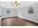 Light-filled bedroom with tray ceiling, fan, and abundant natural light from two windows at 3640 Silver Leaf Sw Ln, Marietta, GA 30008