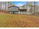 View of the gray home with white trim and front porch situated on a grassy, tree-filled lot at 3640 Silver Leaf Sw Ln, Marietta, GA 30008