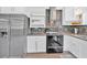 Close up of a kitchen featuring stainless steel appliances, tile backsplash, and white cabinets at 3640 Silver Leaf Sw Ln, Marietta, GA 30008