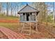 Elevated playhouse with ladder access is surrounded by a leafy backyard with brick path at 3640 Silver Leaf Sw Ln, Marietta, GA 30008