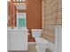 Clean bathroom featuring a white vanity, toilet, and an orange striped shower curtain at 917 Redstone Trl, Dacula, GA 30019