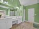 Bright bathroom featuring dual sinks, white cabinets, and a vanity area at 917 Redstone Trl, Dacula, GA 30019