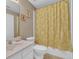 Bright bathroom with white vanity, toilet, and a floral shower curtain, plus framed art at 917 Redstone Trl, Dacula, GA 30019