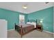 Inviting bedroom with bright teal walls, comfortable bed, and ample natural light from the window at 917 Redstone Trl, Dacula, GA 30019