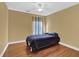 Simple bedroom with wood floors, ceiling fan, and window with blue curtains at 917 Redstone Trl, Dacula, GA 30019