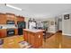 Bright kitchen with wood cabinets, island with seating, hardwood floors, and an adjacent dining area at 917 Redstone Trl, Dacula, GA 30019