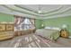 Main bedroom with tray ceiling, ceiling fan, large window and neutral color carpet at 917 Redstone Trl, Dacula, GA 30019