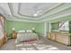 Main bedroom featuring tray ceilings, a ceiling fan, dresser, and large windows at 917 Redstone Trl, Dacula, GA 30019
