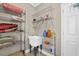 Practical utility room with storage shelves, utility sink, and organized cleaning supplies at 917 Redstone Trl, Dacula, GA 30019