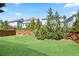 Large backyard with a wooden fence, green grass, and lush trees and bushes at 11395 Crestview Ter, Johns Creek, GA 30024