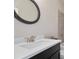 Bathroom with black vanity cabinet, white countertop and oval mirror at 11395 Crestview Ter, Johns Creek, GA 30024