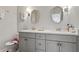 Bright bathroom with double sink vanity featuring round mirrors and a christmas toilet cover at 11395 Crestview Ter, Johns Creek, GA 30024