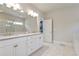 Bright bathroom featuring double vanity with white cabinetry, a large mirror, and a glass-enclosed shower at 11395 Crestview Ter, Johns Creek, GA 30024