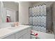 Well-lit bathroom featuring a shower over tub, single sink vanity, and neutral decor at 11395 Crestview Ter, Johns Creek, GA 30024