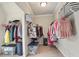Walk-in closet with ample storage space, shelving, and rods for hanging clothes; complete with carpeted flooring at 11395 Crestview Ter, Johns Creek, GA 30024