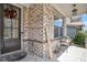 Inviting front porch with brick flooring, a welcome sign, seating, and a decorative wreath on the front door at 11395 Crestview Ter, Johns Creek, GA 30024
